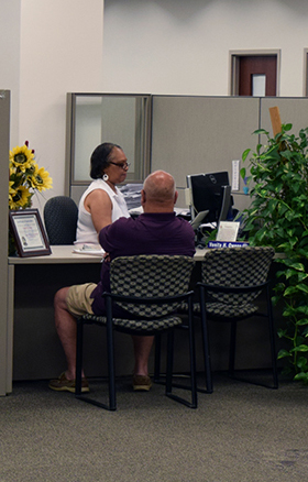 A building permitting clerk works with a customer.
