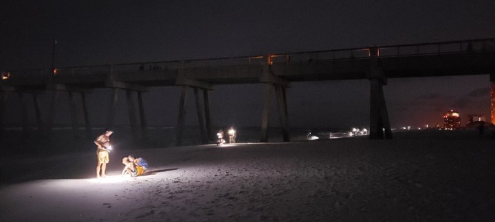White Lights on the Beach People using white lights on the beach at night